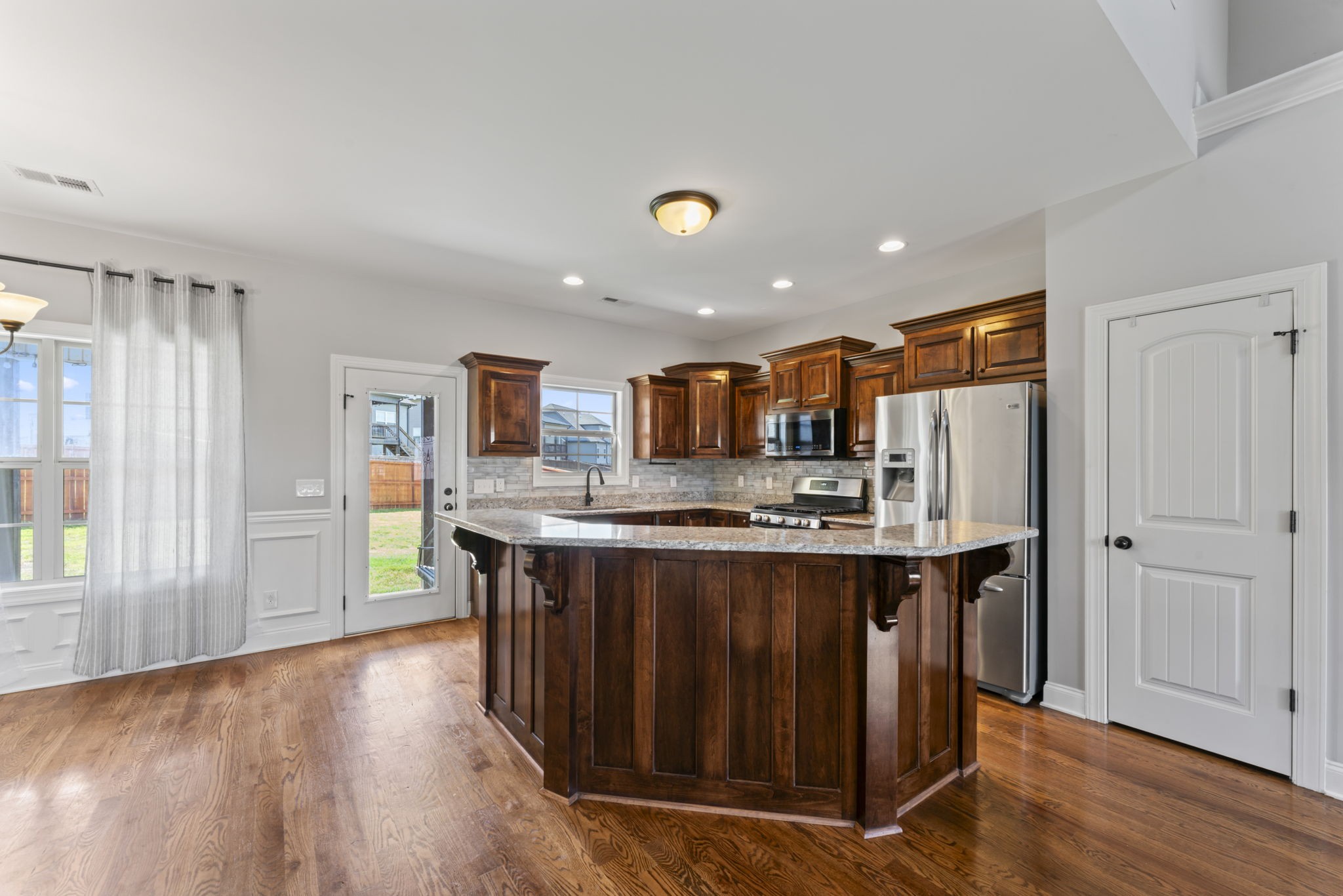 2314 Tranquility Trail Smyrna, TN 37167 - Photo 9 of 35 a kitchen with stainless steel appliances granite countertop a refrigerator a sink dishwasher a stove and a dining table with wooden floor