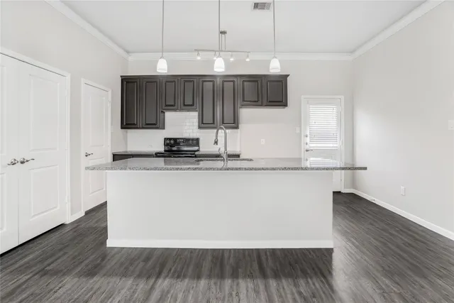 a kitchen with sink cabinets and wooden floor