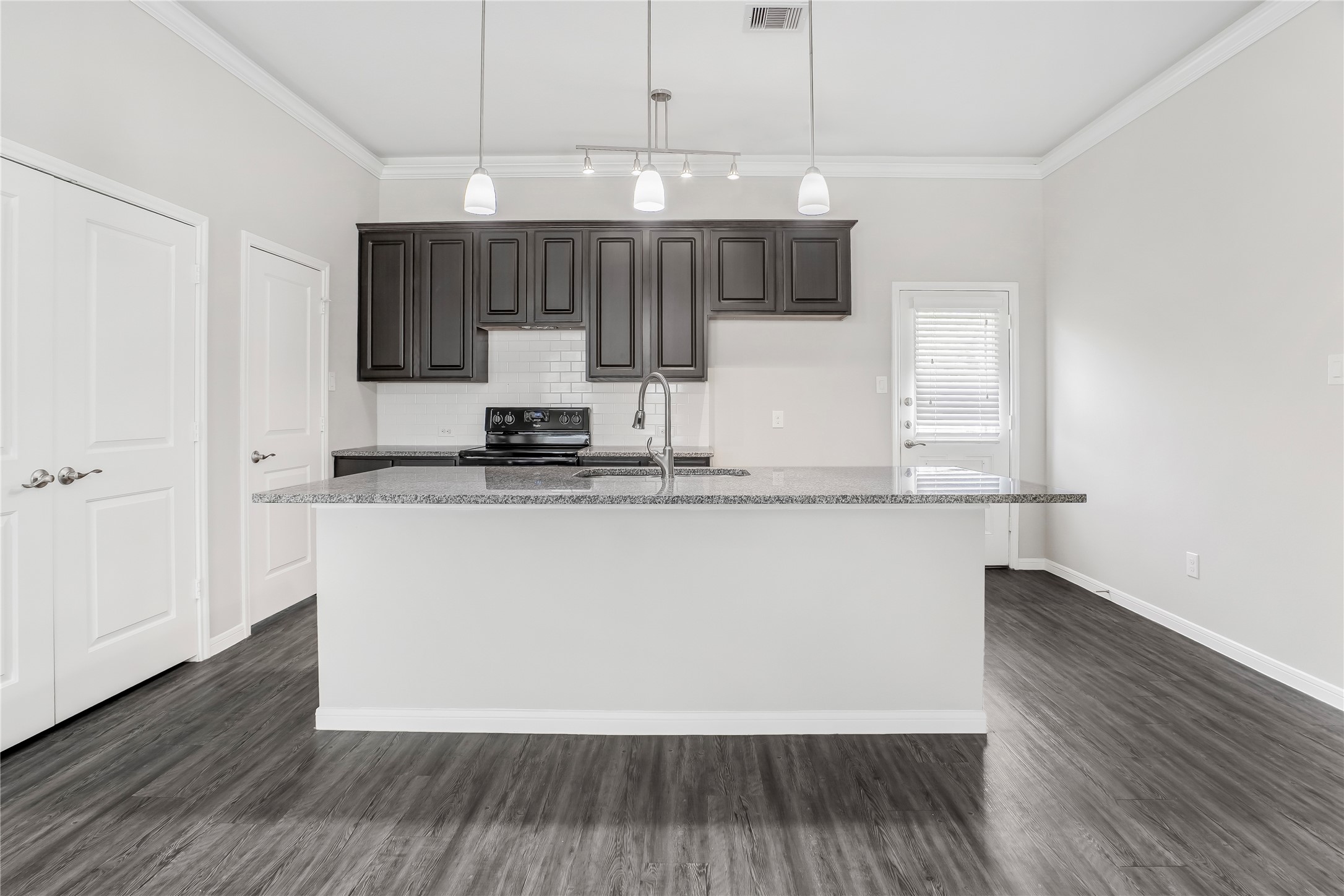 6532 Geisler Crossing Lane League City, TX 77539 - Photo 10 of 28 a kitchen with kitchen island white cabinets and wooden floor