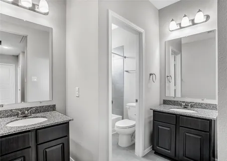 a bathroom with a granite countertop tub sink shower and a mirror