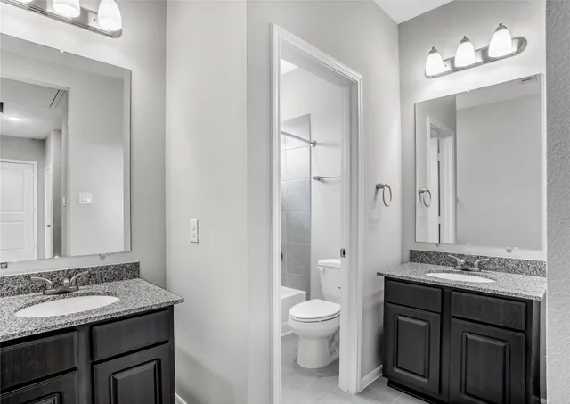 a bathroom with a granite countertop tub sink shower and a mirror