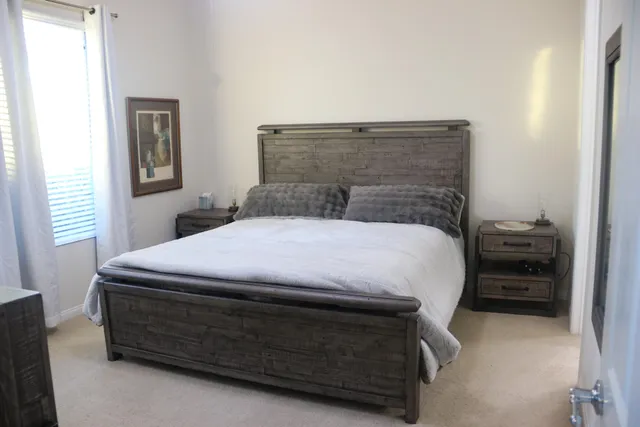 a bed sitting in a bedroom next to a window