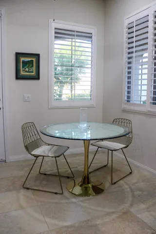 a view of a workspace room with furniture and a window