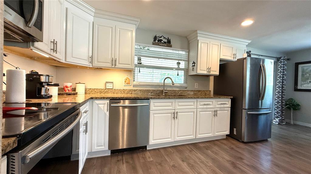 111 Palencia Road Auburndale, FL 33823 - Photo 5 of 28 a kitchen with refrigerator cabinets and wooden floor