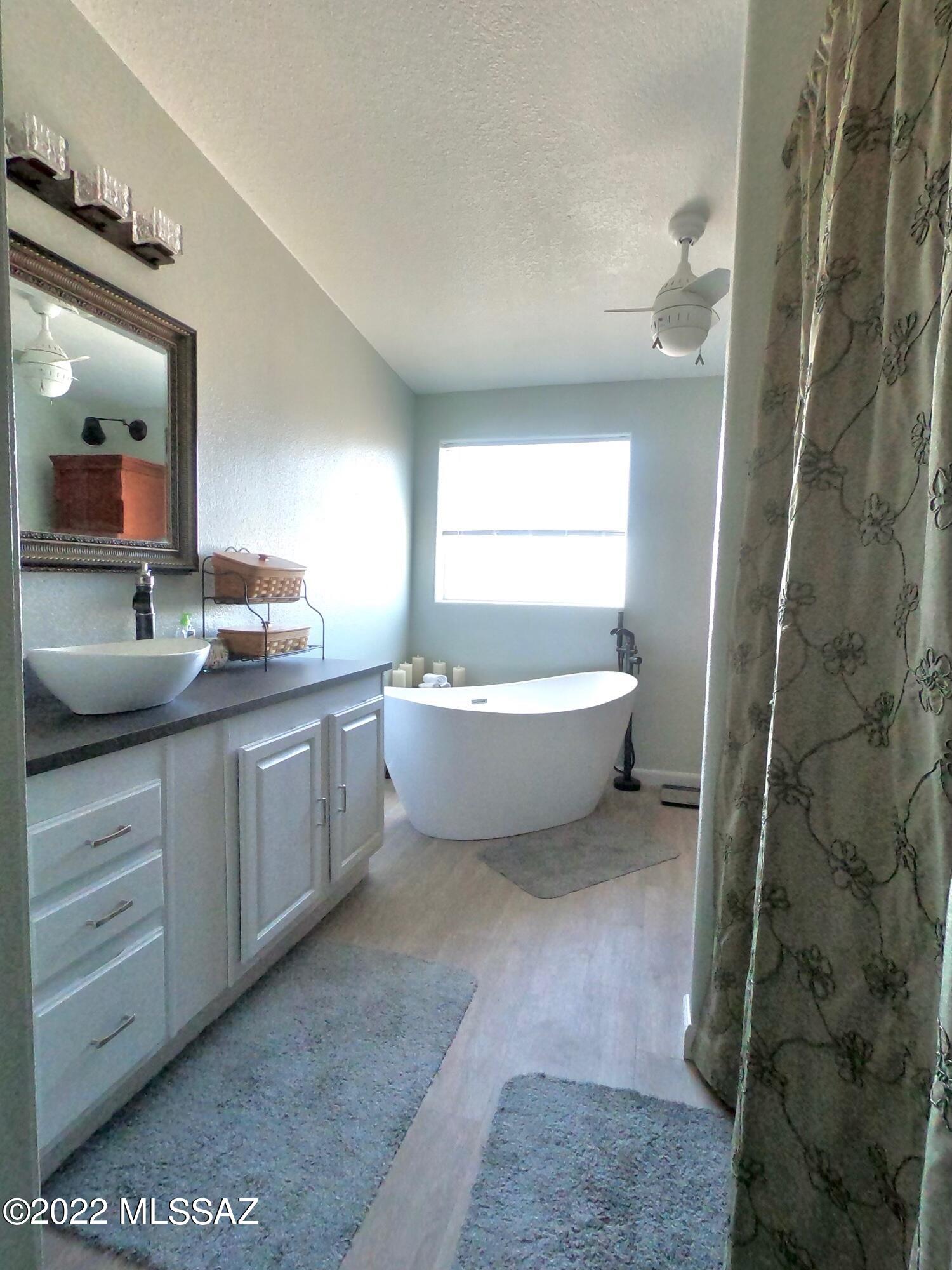 13643 East Bright Sky Loop Vail, AZ 85641 - Photo 15 of 22 a bathroom with a double vanity sink a mirror and a bathtub