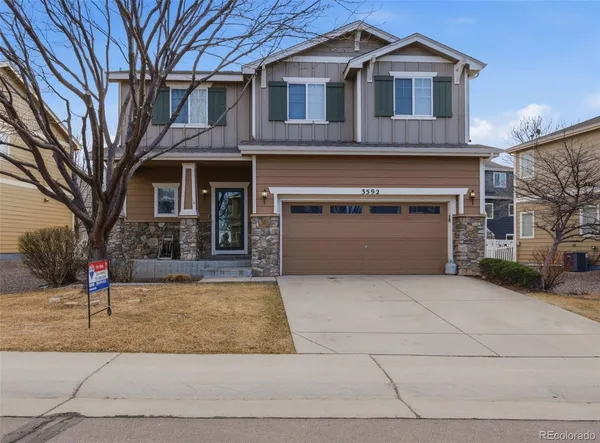 a front view of a house with yard and parking