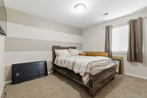 a bed sitting in a spacious bedroom next to a window