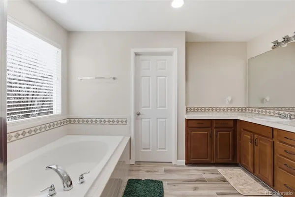 a bathroom with a tub a sink and a window