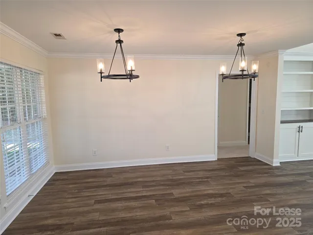a view of a room with wooden floor window and a chandelier