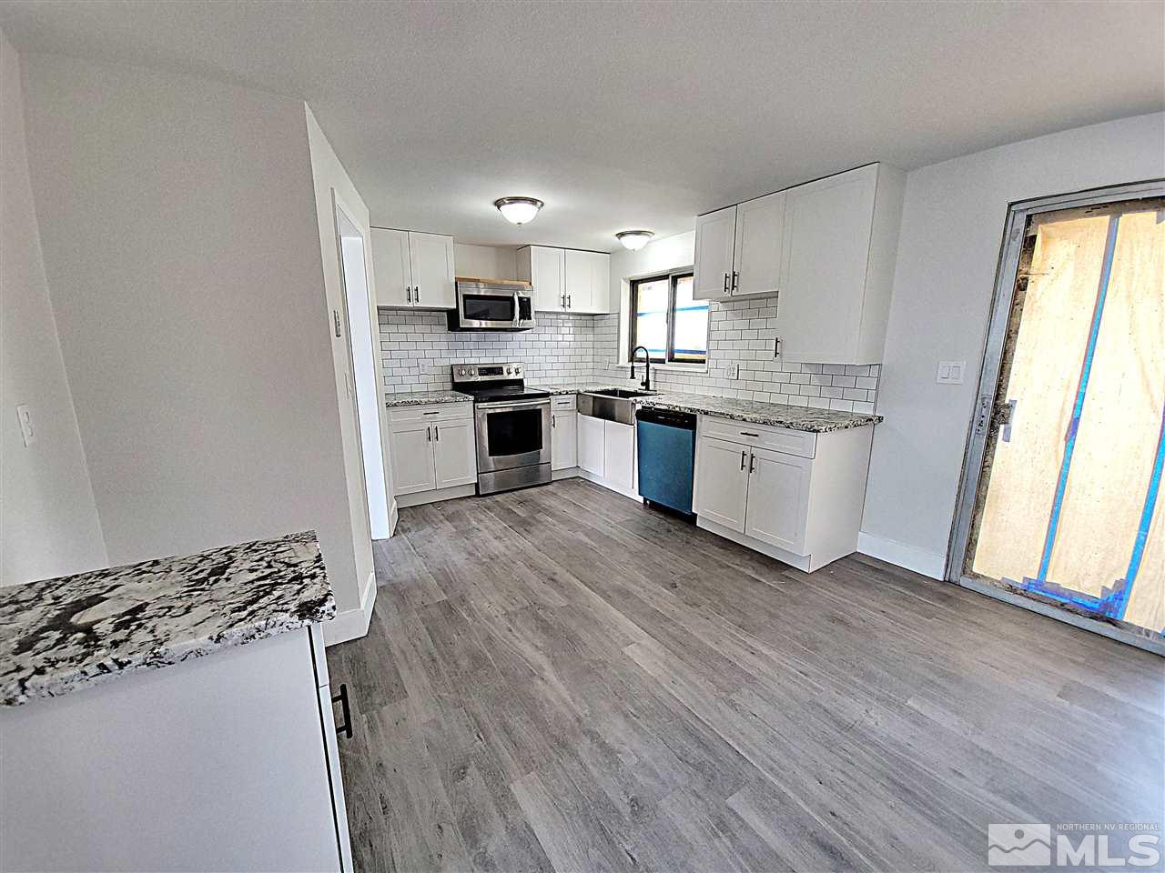 1901 Carlin Street Reno, NV 89503 - Photo 8 of 10 a kitchen with stainless steel appliances granite countertop a stove top oven a sink a refrigerator white cabinets and wooden floor