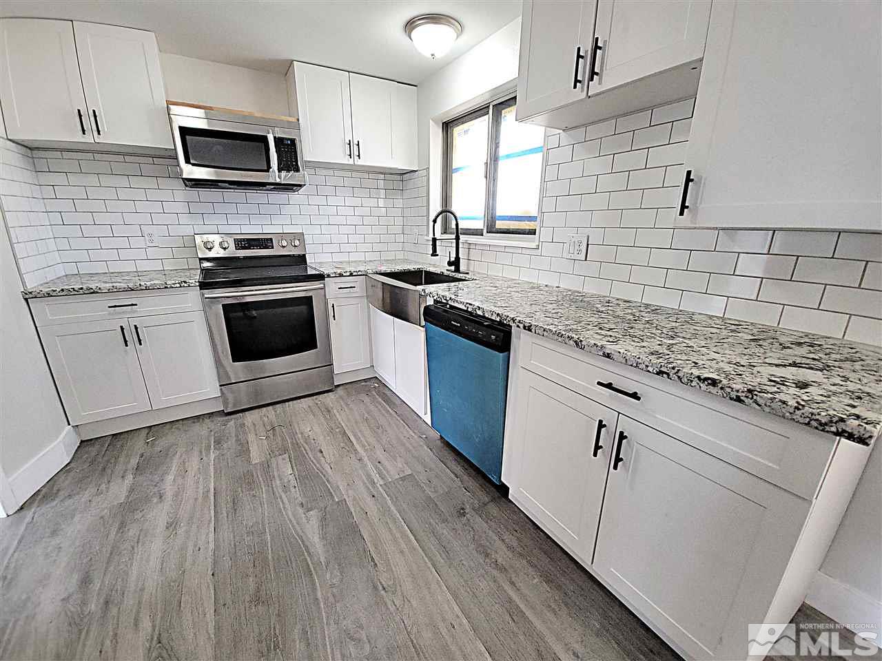 1901 Carlin Street Reno, NV 89503 - Photo 9 of 10 a kitchen with stainless steel appliances granite countertop a stove a sink and a microwave
