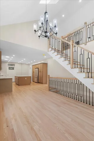 a view of a chandelier and staircase with wooden floor