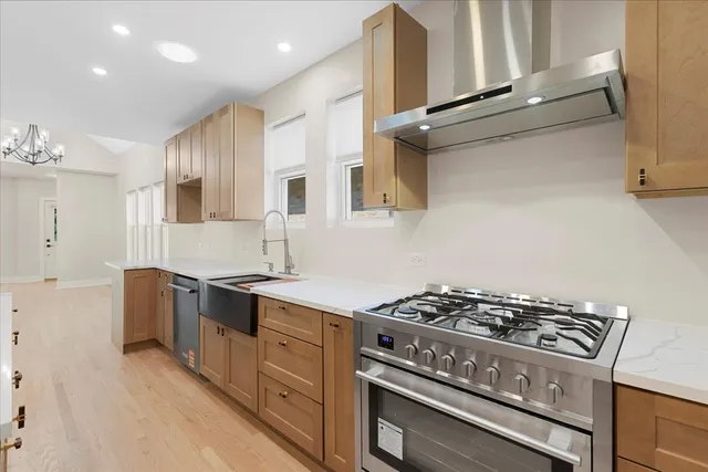 a kitchen with stainless steel appliances a sink dishwasher stove and refrigerator