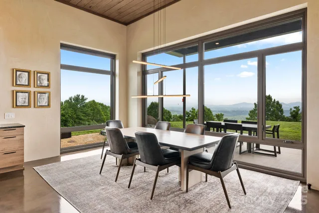a dining room with furniture and a floor to ceiling window
