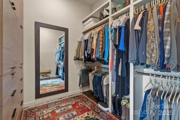 a view of walk in closet with clothes and shoes