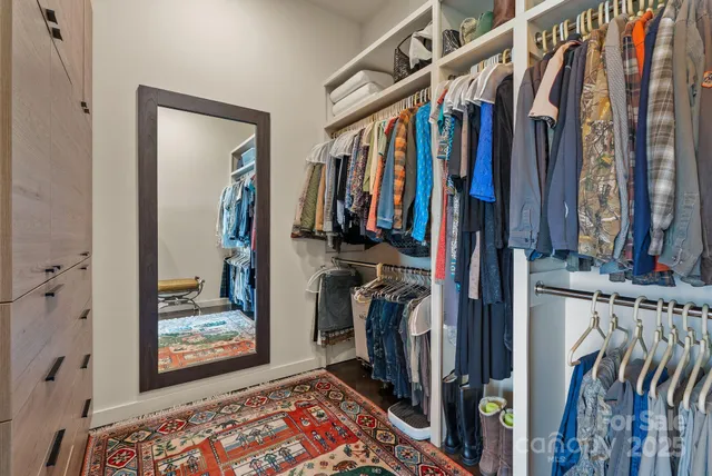 a view of walk in closet with clothes and shoes