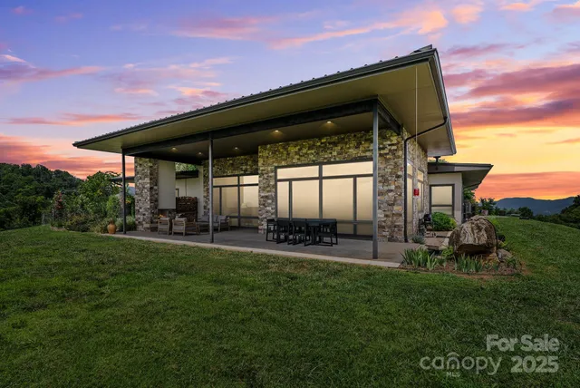 a view of a backyard with table and chairs under an umbrella