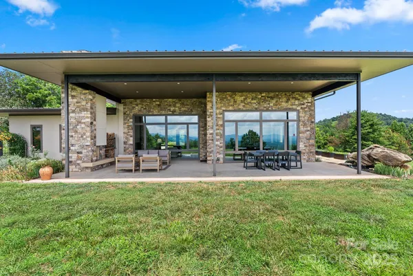 a view of a house with a backyard patio and swimming pool