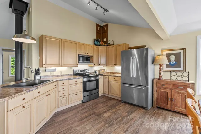 a kitchen with granite countertop a refrigerator stove top oven and sink
