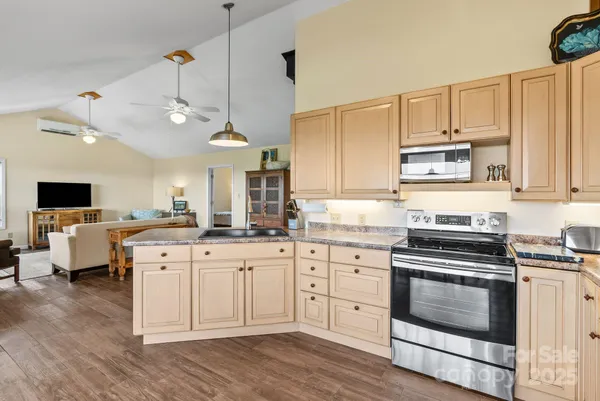 a kitchen with cabinets appliances and a wooden floor