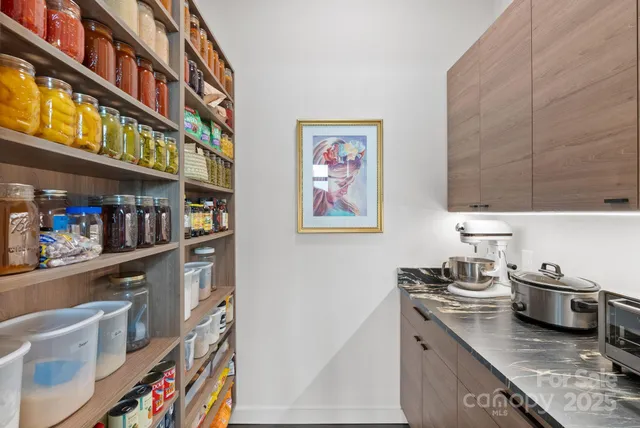 a kitchen with stainless steel appliances granite countertop a lot of cabinets and wooden floor