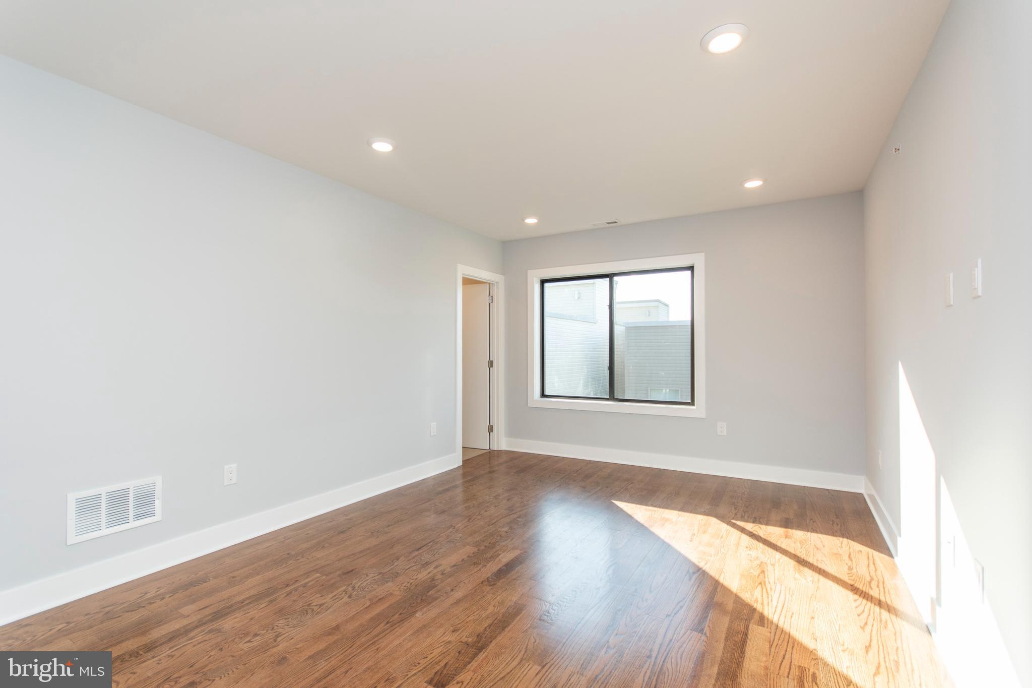 812 North Uber Street, Unit 6 Philadelphia, PA 19130 - Photo 12 of 25 an empty room with wooden floor and windows
