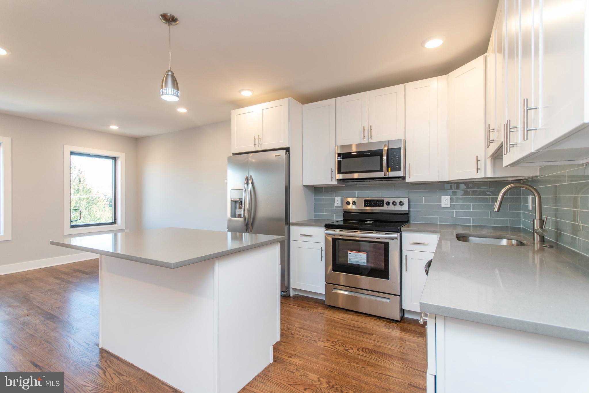812 North Uber Street, Unit 6 Philadelphia, PA 19130 - Photo 4 of 25 a kitchen with stainless steel appliances granite countertop a stove a sink and a refrigerator