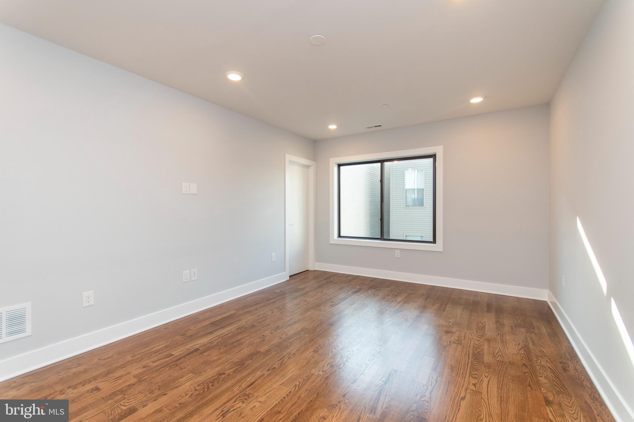 812 North Uber Street, Unit 6 Philadelphia, PA 19130 - Photo 6 of 25 a view of an empty room with wooden floor and a window