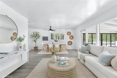 a living room with furniture tv and large windows