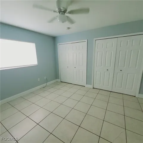 a view of an empty room and chandelier fan