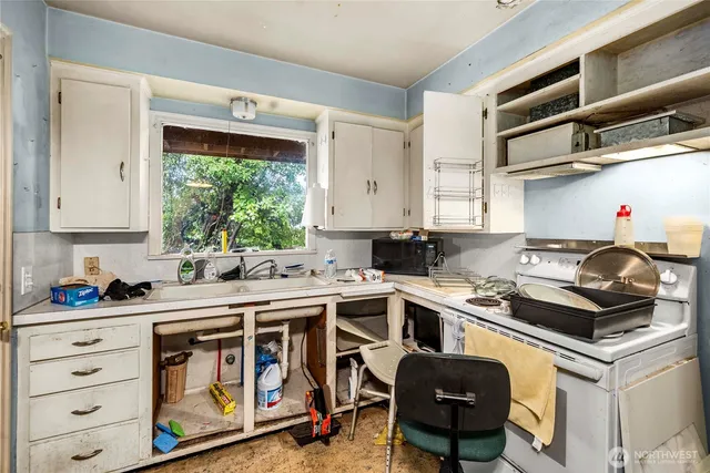 a kitchen with a stove sink and cabinets