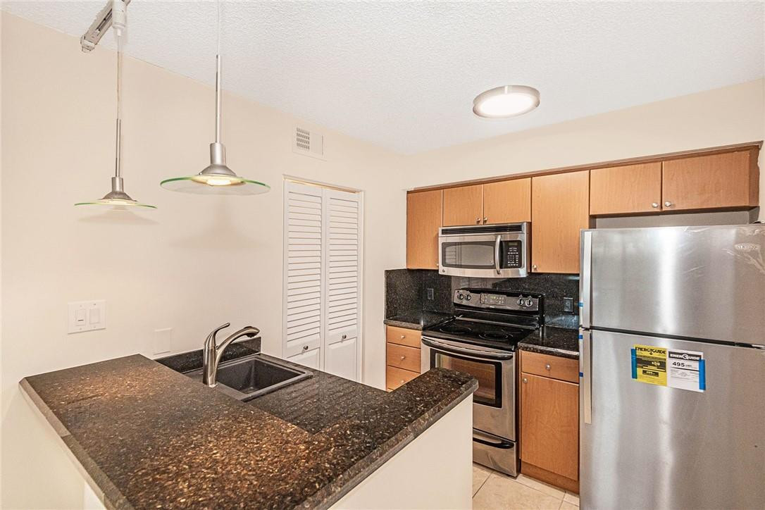 620 South Park Road, Unit 213 Hollywood, FL 33021 - Photo 2 of 28 a kitchen with stainless steel appliances granite countertop a sink refrigerator and microwave