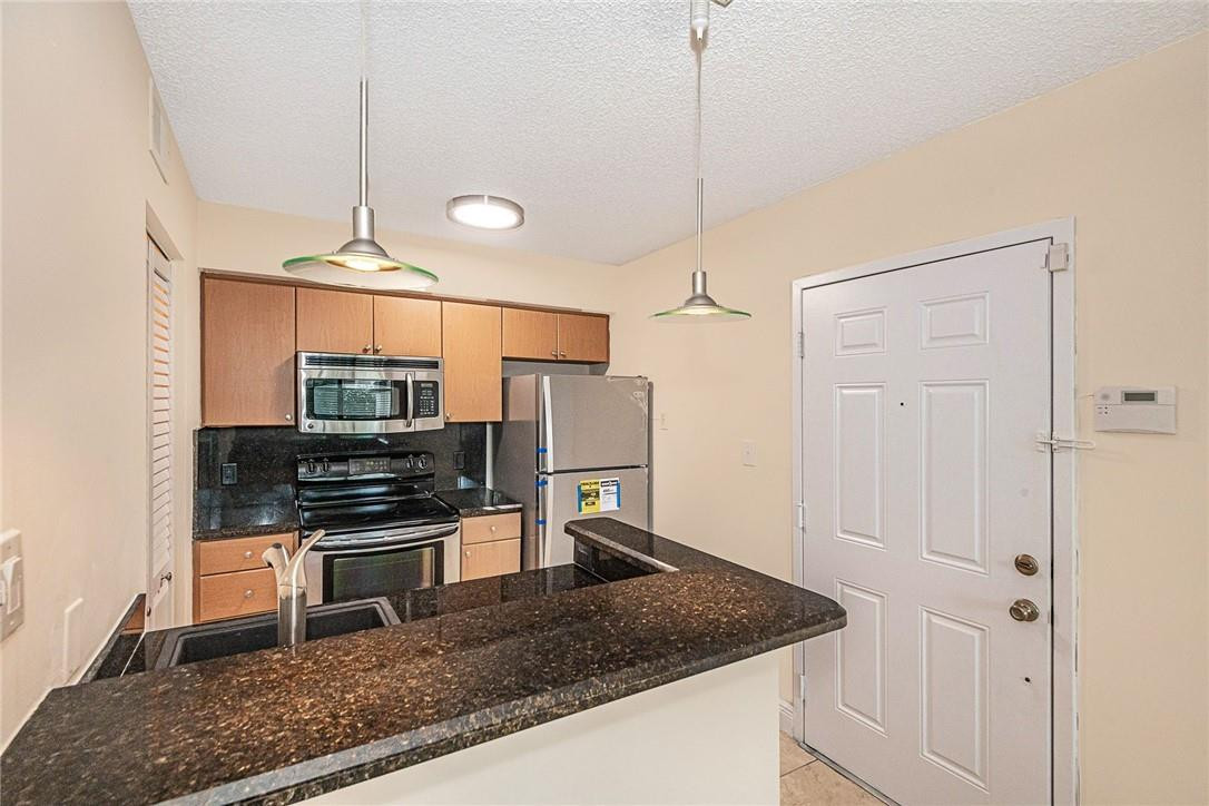 620 South Park Road, Unit 213 Hollywood, FL 33021 - Photo 5 of 28 a kitchen with stainless steel appliances granite countertop a stove a refrigerator and a sink