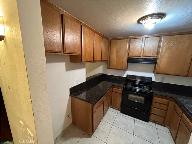 a kitchen with granite countertop stainless steel appliances and wooden cabinets