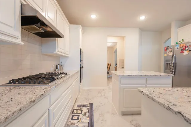 a kitchen with stainless steel appliances granite countertop a sink and a stove