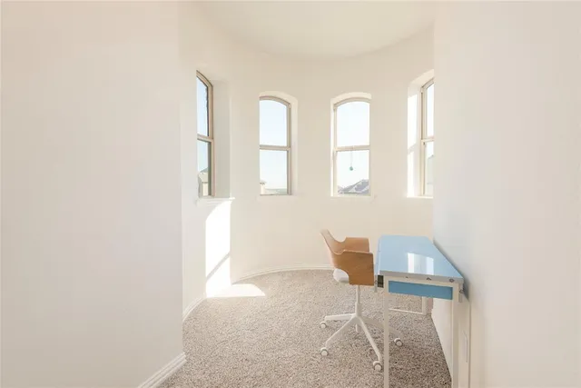 a view of an empty room with wooden floor and windows