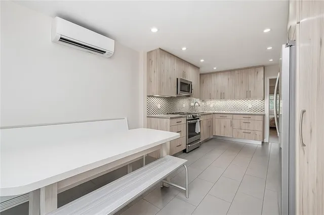 a kitchen with granite countertop white cabinets and stainless steel appliances