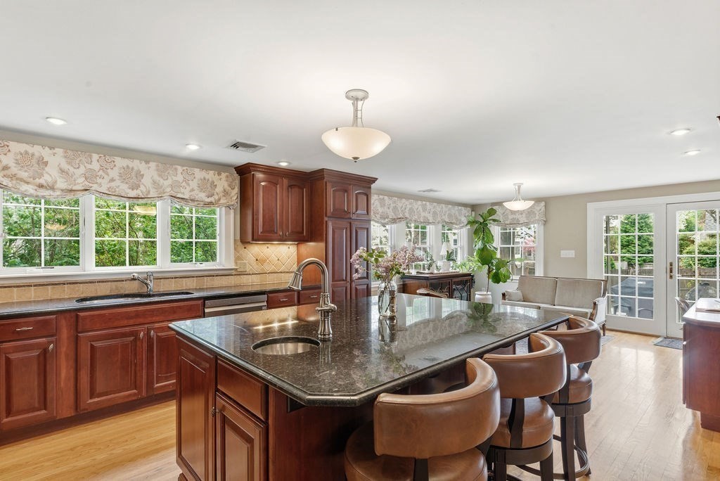 57 Douglas Road Needham, MA 02492 - Photo 6 of 22 a kitchen with a table chairs and wooden floor
