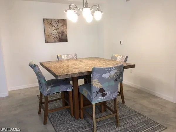 a kitchen with stainless steel appliances kitchen island granite countertop a sink a stove a dining table and chairs