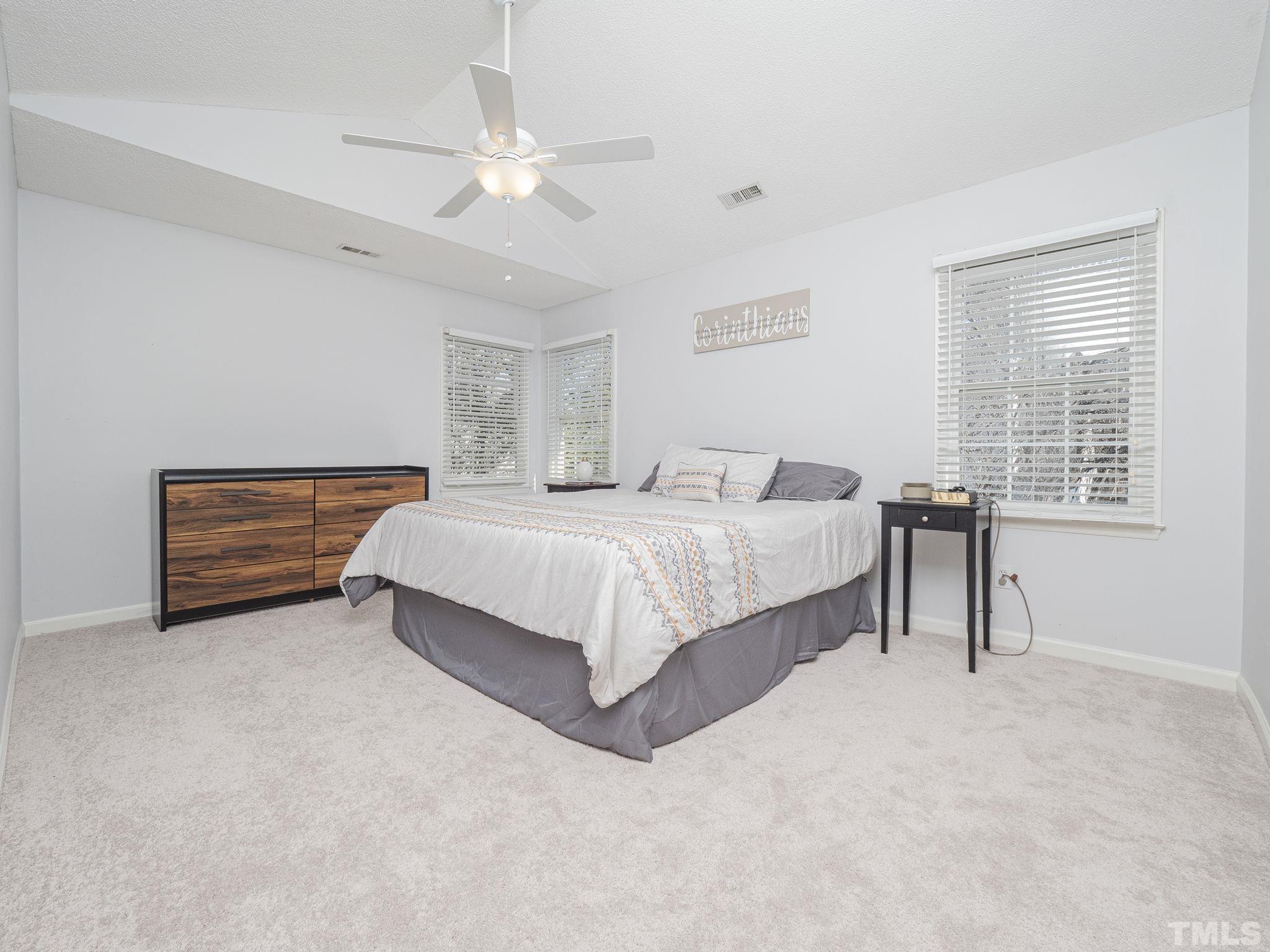 11233 North Radner Way Raleigh, NC 27613 - Photo 7 of 15 a spacious bedroom with a bed and a chandelier