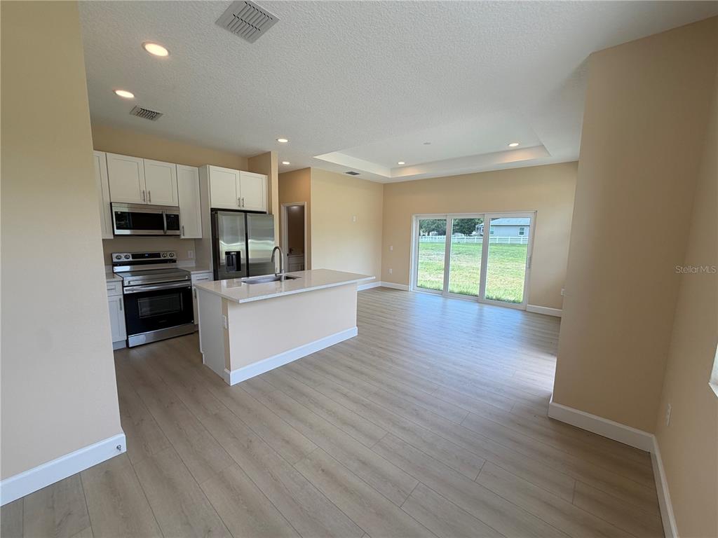 4661 Hickory Tree Road St. Cloud, FL 34772 - Photo 7 of 20 a large kitchen with stainless steel appliances a large counter top a stove and a refrigerator