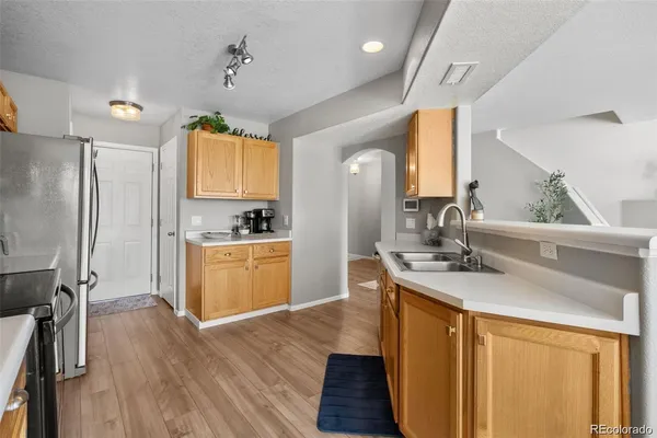 a kitchen with kitchen island granite countertop a sink appliances cabinets and wooden floor