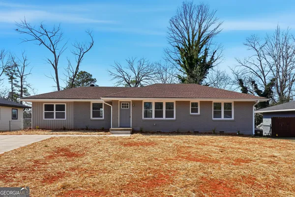 a front view of house with yard and trees around