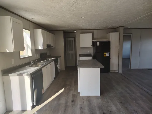 a kitchen with stainless steel appliances granite countertop a refrigerator a sink and a stove