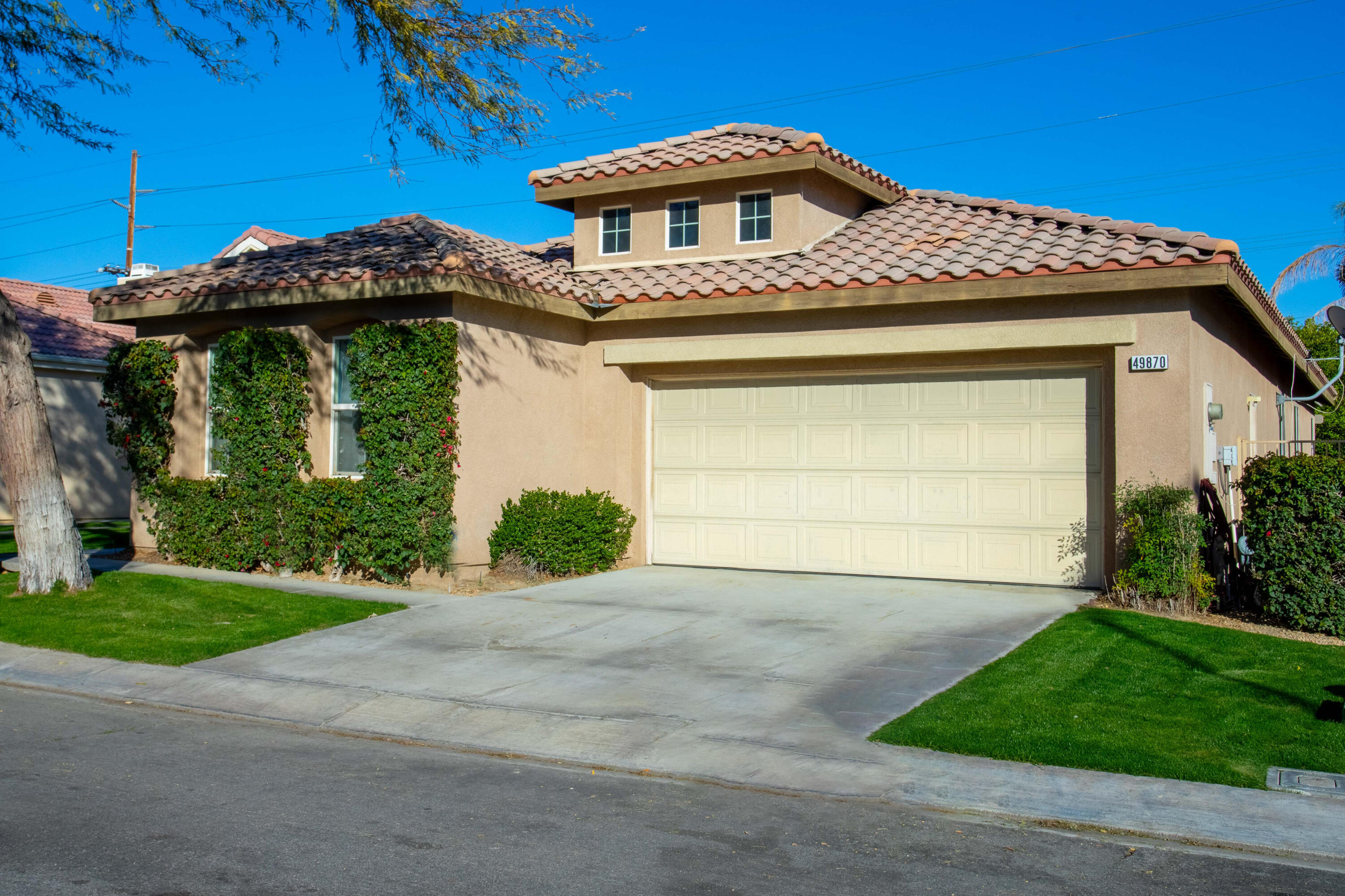 49870 Lewis Road Indio, CA 92201 - Photo 3 of 47 a front view of a house with a yard and garage