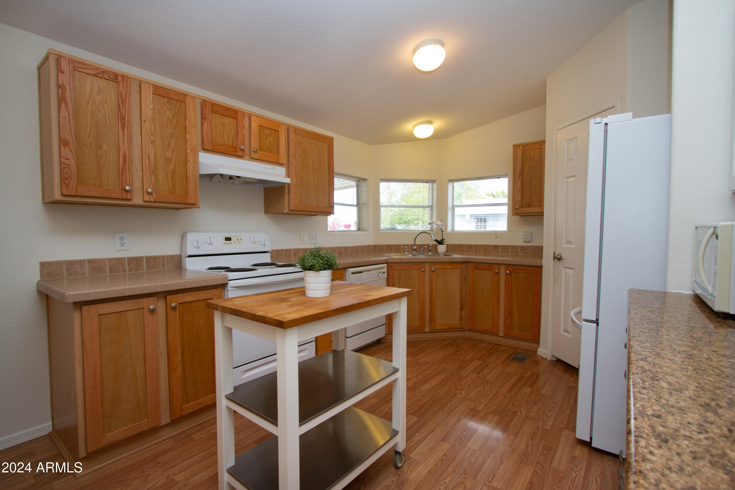 3700 South Tomahawk Road, Unit 93 Apache Junction, AZ 85119 - Photo 18 of 40 a kitchen with a stove a sink and a refrigerator