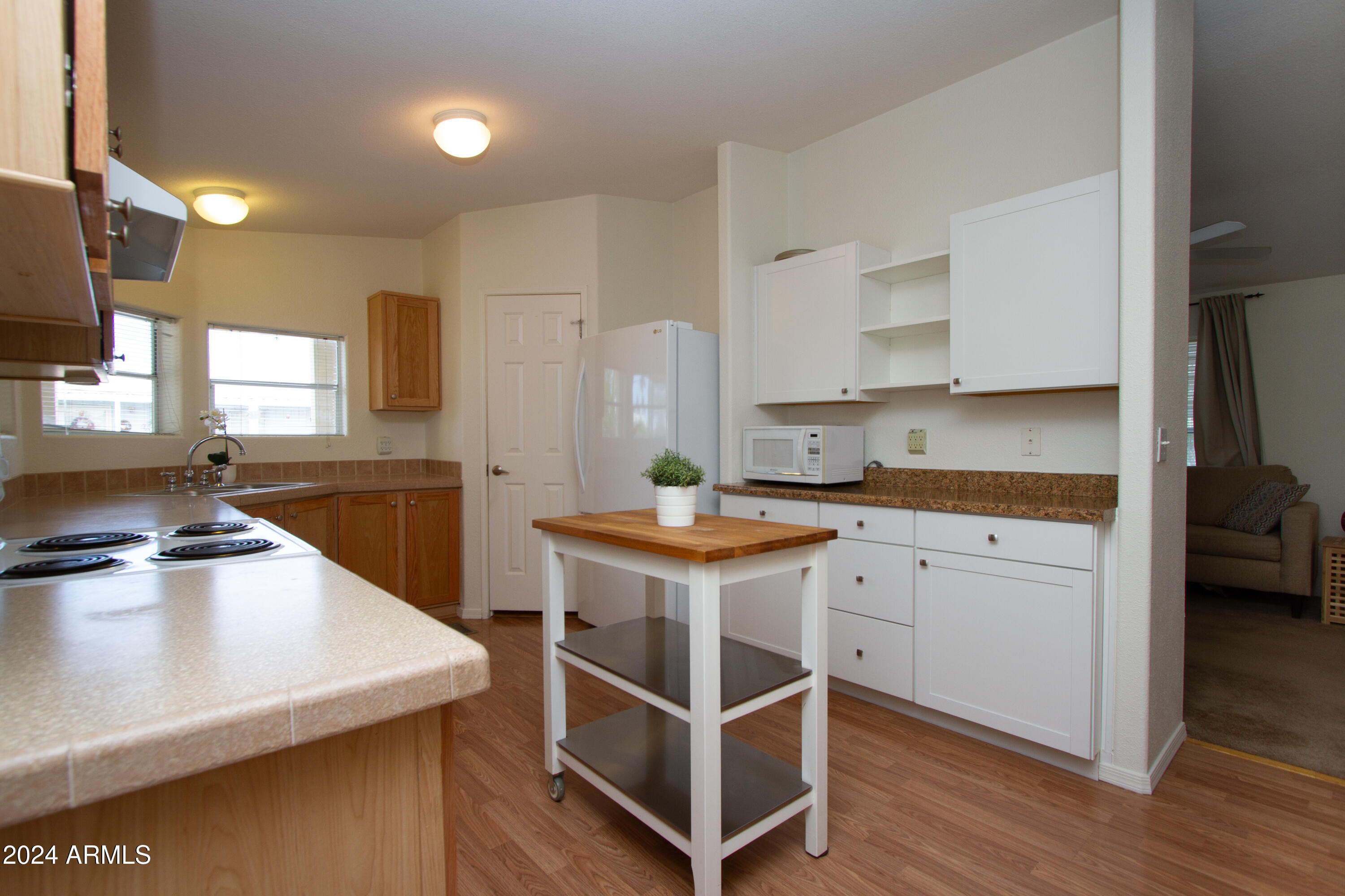 3700 South Tomahawk Road, Unit 93 Apache Junction, AZ 85119 - Photo 19 of 40 a kitchen that has a lot of cabinets in it and wooden floors
