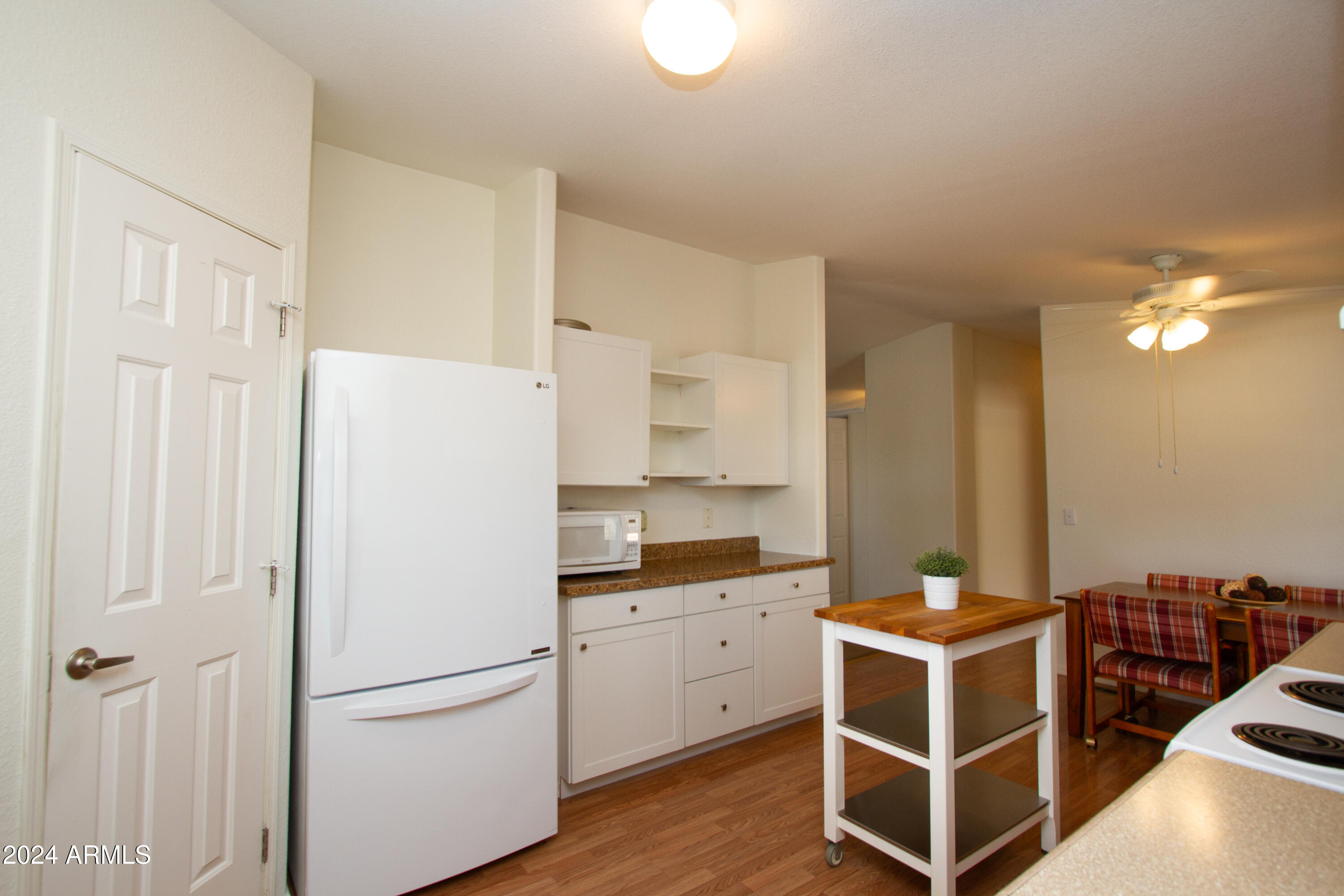 3700 South Tomahawk Road, Unit 93 Apache Junction, AZ 85119 - Photo 22 of 40 a kitchen with a refrigerator and cabinets