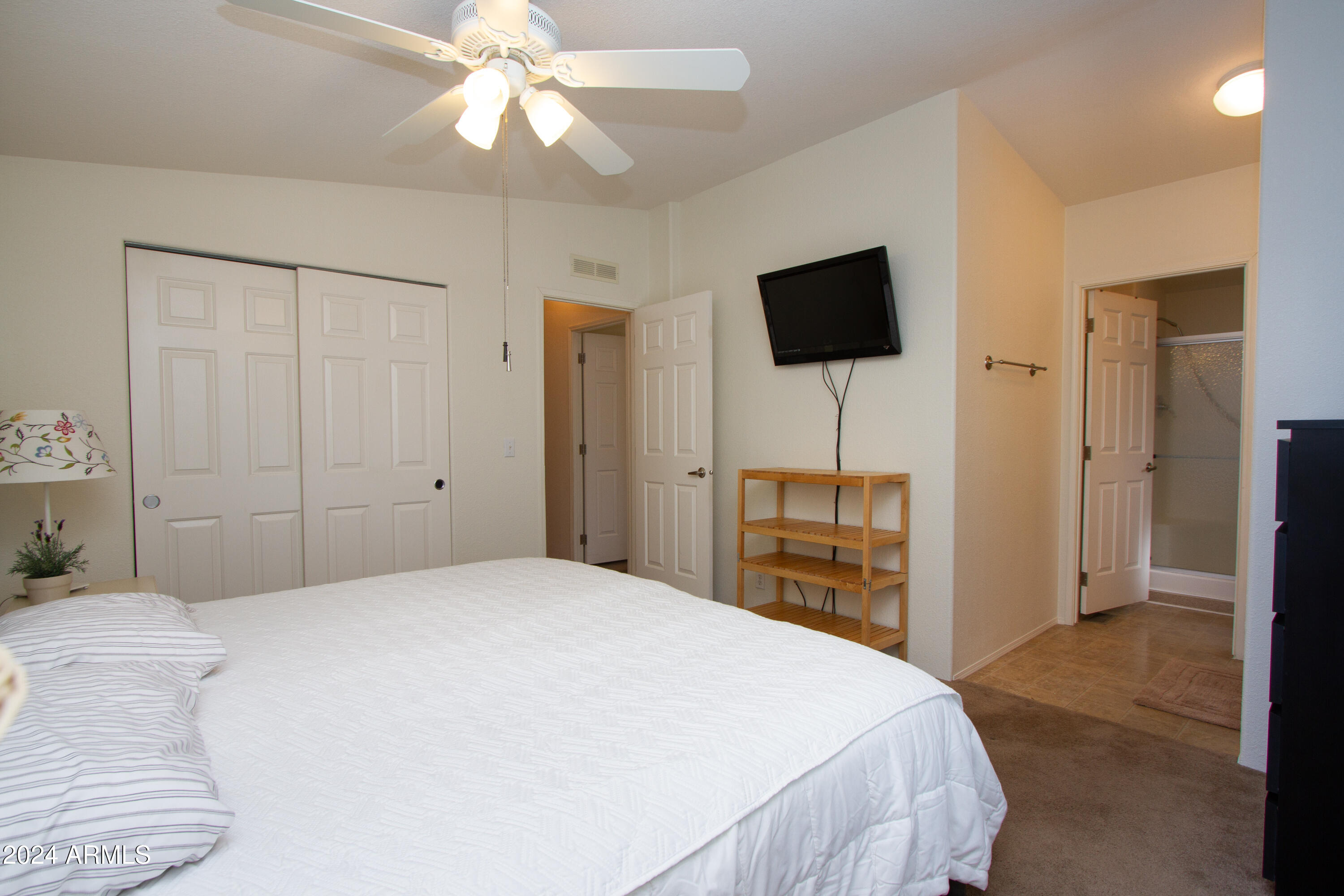 3700 South Tomahawk Road, Unit 93 Apache Junction, AZ 85119 - Photo 24 of 40 a bedroom with a bed and a flat tv screen on dresser