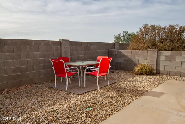 a lawn chairs sitting in a backyard of a house
